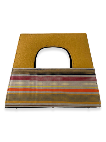 Contemporary luxury A-handle designer handbag crafted from mercerized Peruvian Pima cotton with multicolor woven stripes in yellow, ivory, orange, red, and charcoal tones. Features a structured yellow pebbled leather handle, navy patent leather interior grip, zip-top closure, and elegant architectural silhouette.