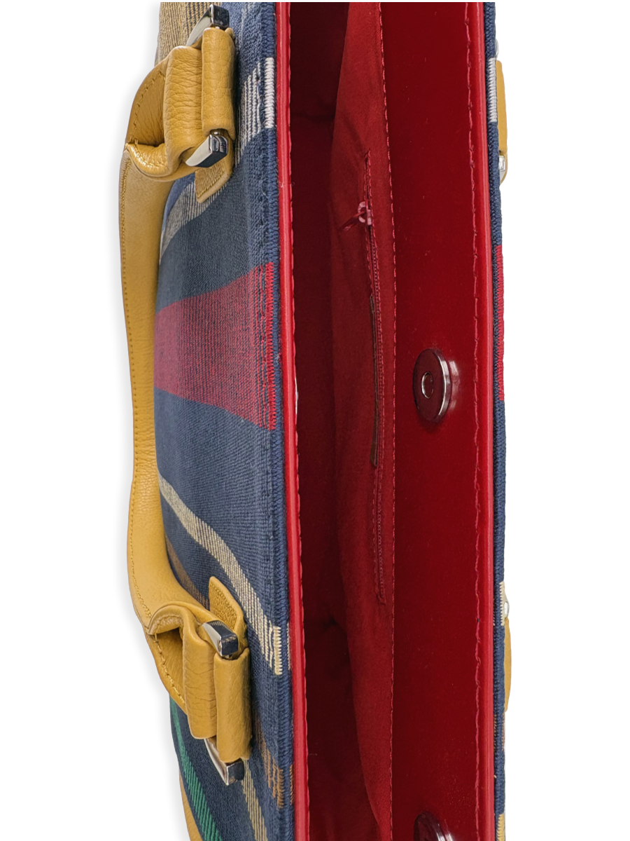 Contemporary designer handbag made in Peru with mercerized Pima cotton, genuine leather trim, structured silhouette, and multicolored woven textile in navy, red, green, and yellow.