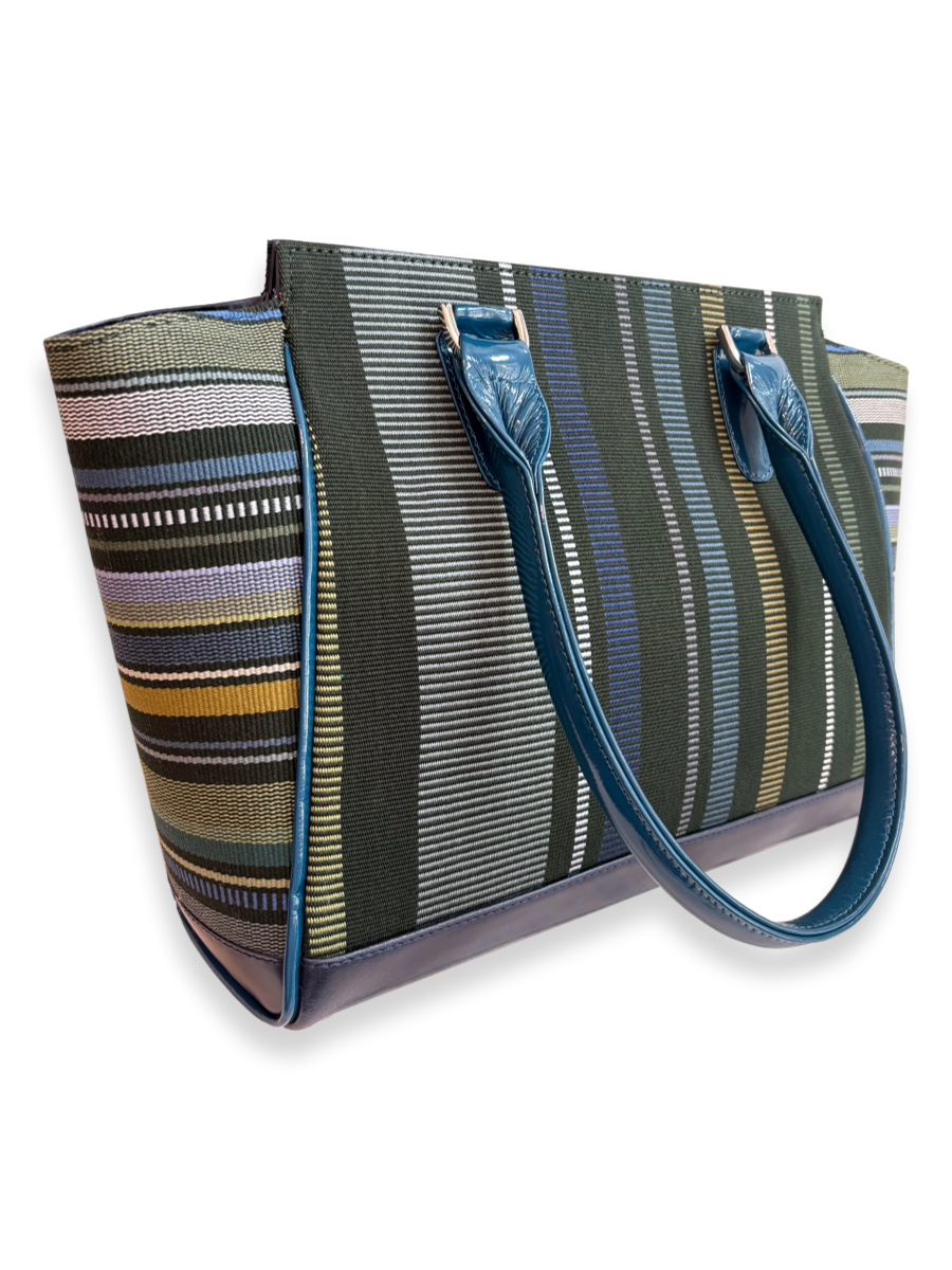 Amanda Grande Kuskaya handbag from Peru with structured silhouette, featuring dark green woven textile with vertical stripes in blue, white, gray, and chartreuse tones, complemented by glossy blue leather handles and trim; available at Qinti, The Peruvian Shop.