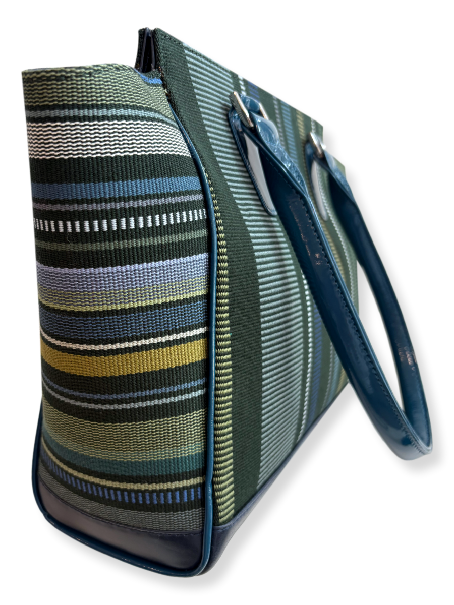 Amanda Grande Kuskaya handbag from Peru with structured silhouette, featuring dark green woven textile with vertical stripes in blue, white, gray, and chartreuse tones, complemented by glossy blue leather handles and trim; available at Qinti, The Peruvian Shop.
