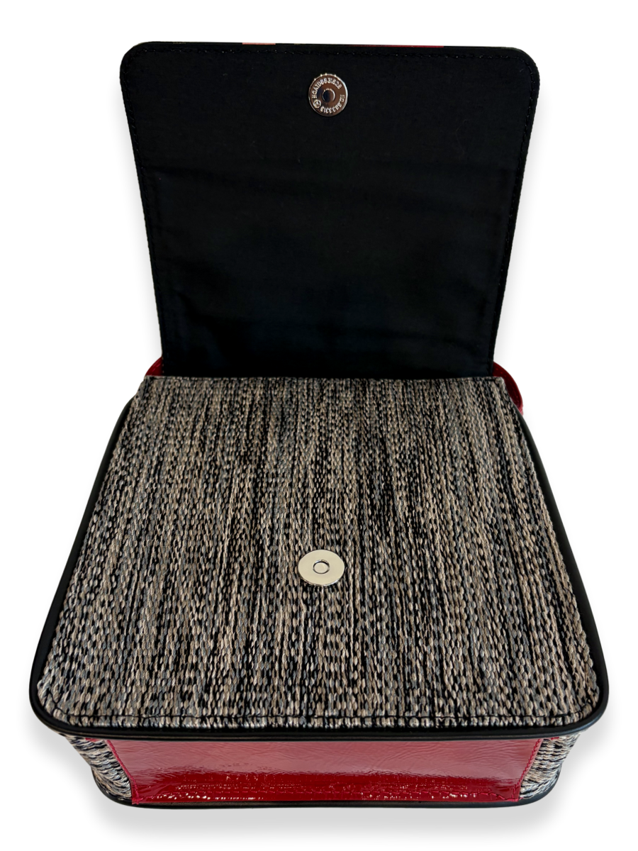 A square clutch bag shown open against a white background, featuring a black fabric interior, a black and beige textured tweed exterior, and a glossy red base.