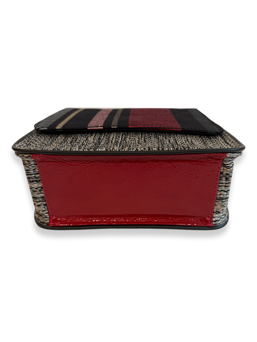 A rectangular clutch bag with a textured black and beige woven pattern, a glossy red front panel, and a matching striped flap in black, red, and beige.