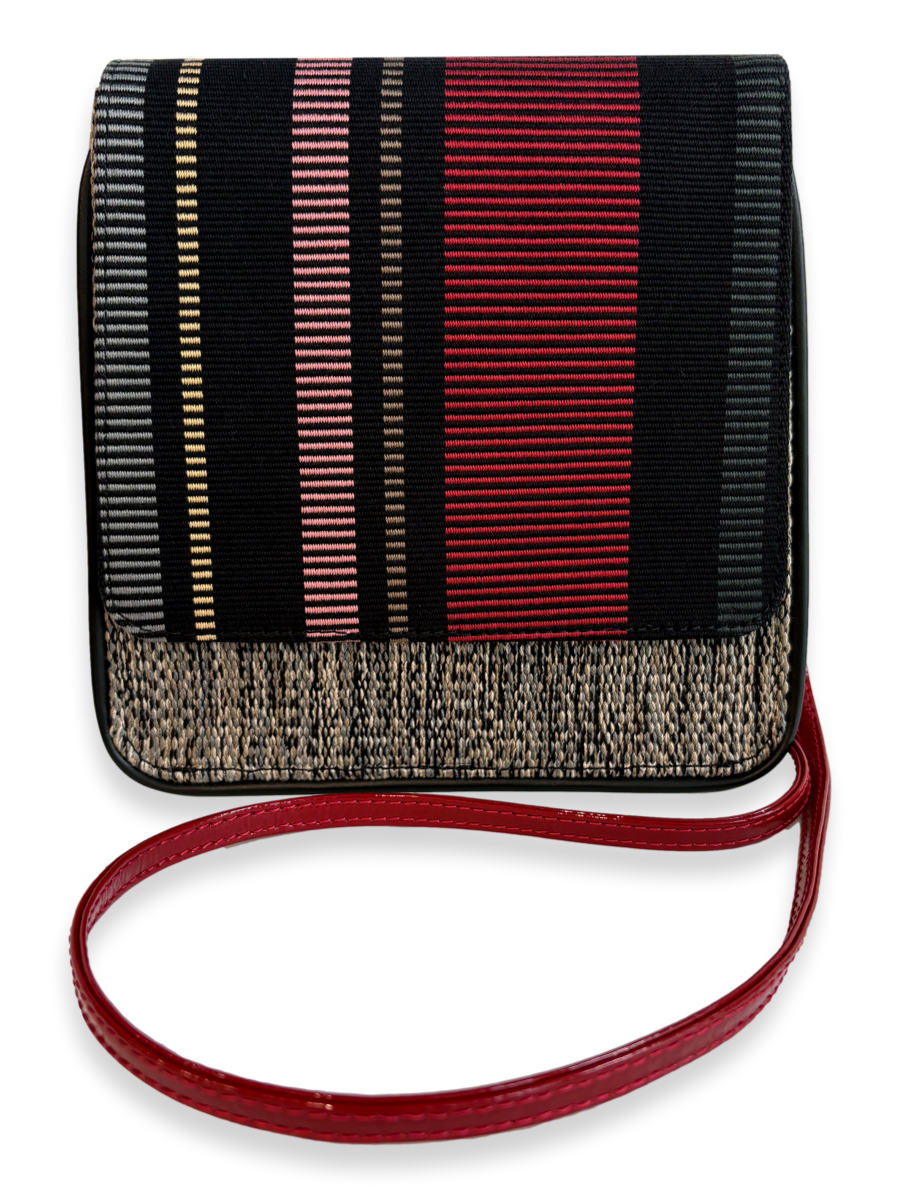 A small rectangular shoulder bag with a black and red vertically striped patterned body, a textured beige woven lower border, and a red strap, shown on a white background.
