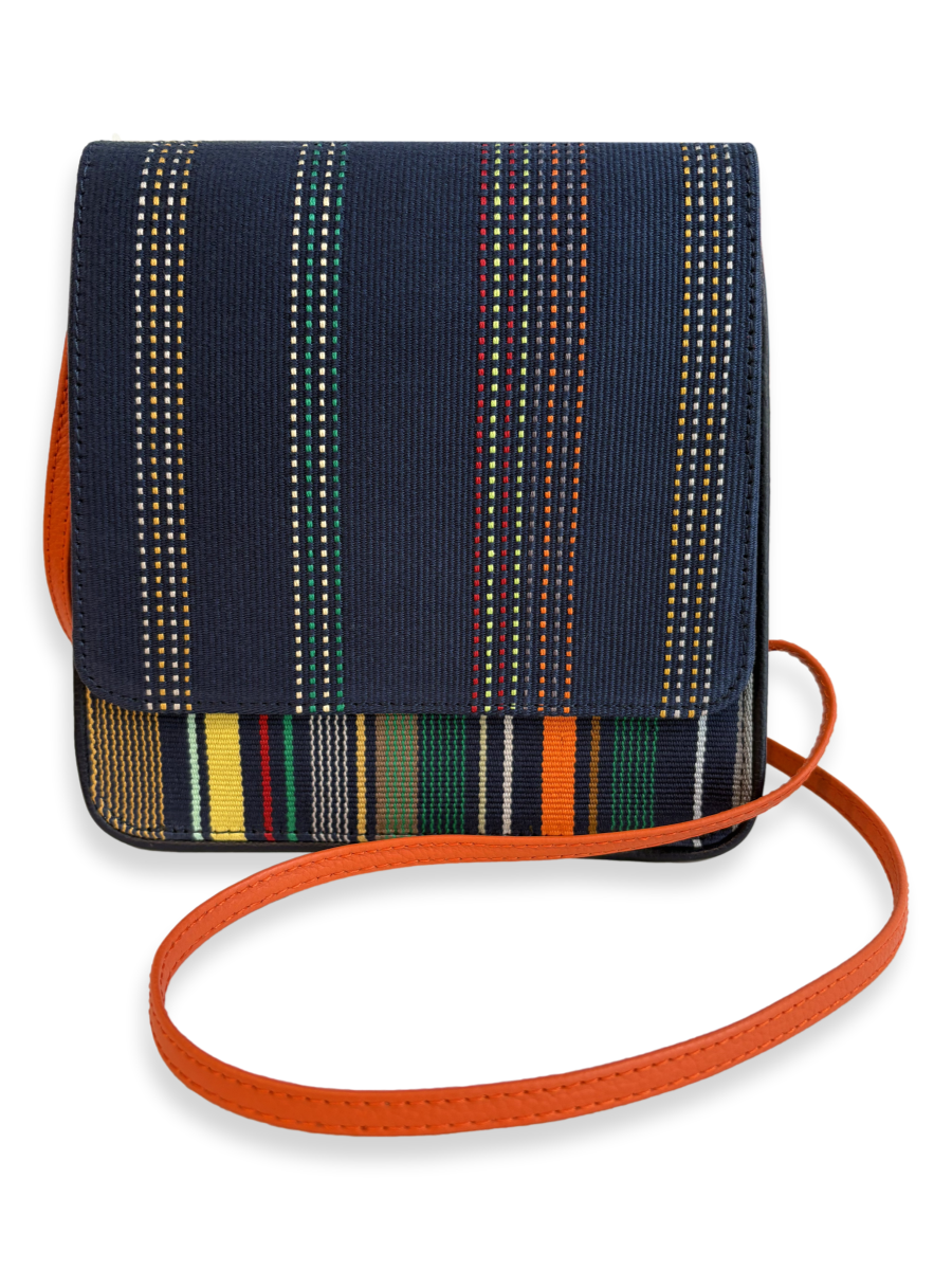 One-of-a-kind Cocktail crossbody handbag handcrafted in Peru with premium mercerized Pima cotton, navy woven textile, orange pebbled leather strap, and contemporary designer styling.