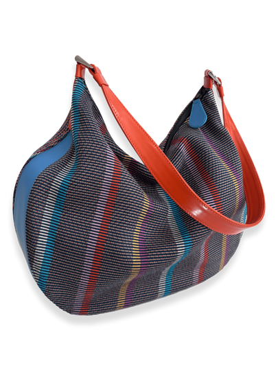 One-of-a-kind Media Luna handbag by Kuskaya made from mercerized Pima cotton from Peru, featuring a crescent shape, multicolored striped textile, double-sided design, and leather trim with a wide shoulder strap. From QINTI The Peruvian Shop.