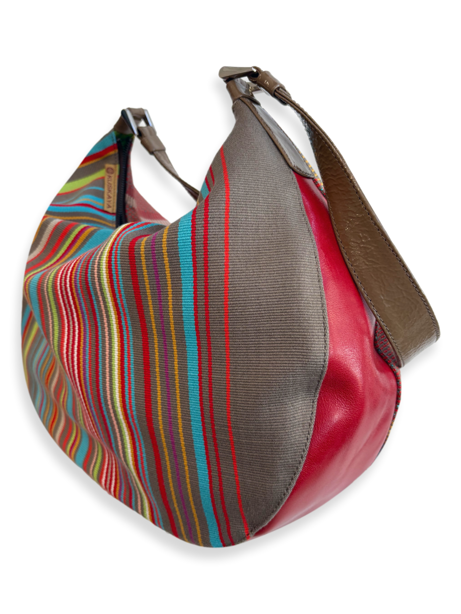 Close-up of handwoven Pima cotton textile with multicolor stripes and brown leather strap detail on KUSKAYA handbag