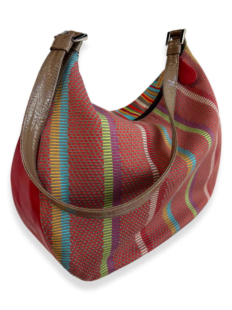 Side view of handwoven Pima cotton handbag with colorful striped pattern and leather trim, medium hobo-style shoulder bag