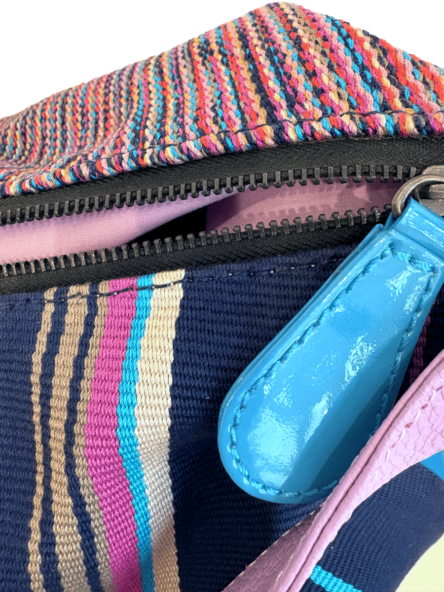 Close-up One-of-a-kind Kuskaya shoulder handbag, crafted from striped multicolor Pima cotton with smooth leather panels, a wide lilac leather strap, and a soft lilac interior; slouchy, crescent shape with artisanal Peruvian design - QINTI The Peruvian Shop