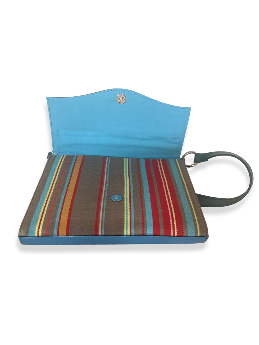 Interior of the Onda luxury handbag featuring an aqua-lined compartment, magnetic snap closure, and premium mercerized Peruvian Pima cotton with vibrant striped detailing.