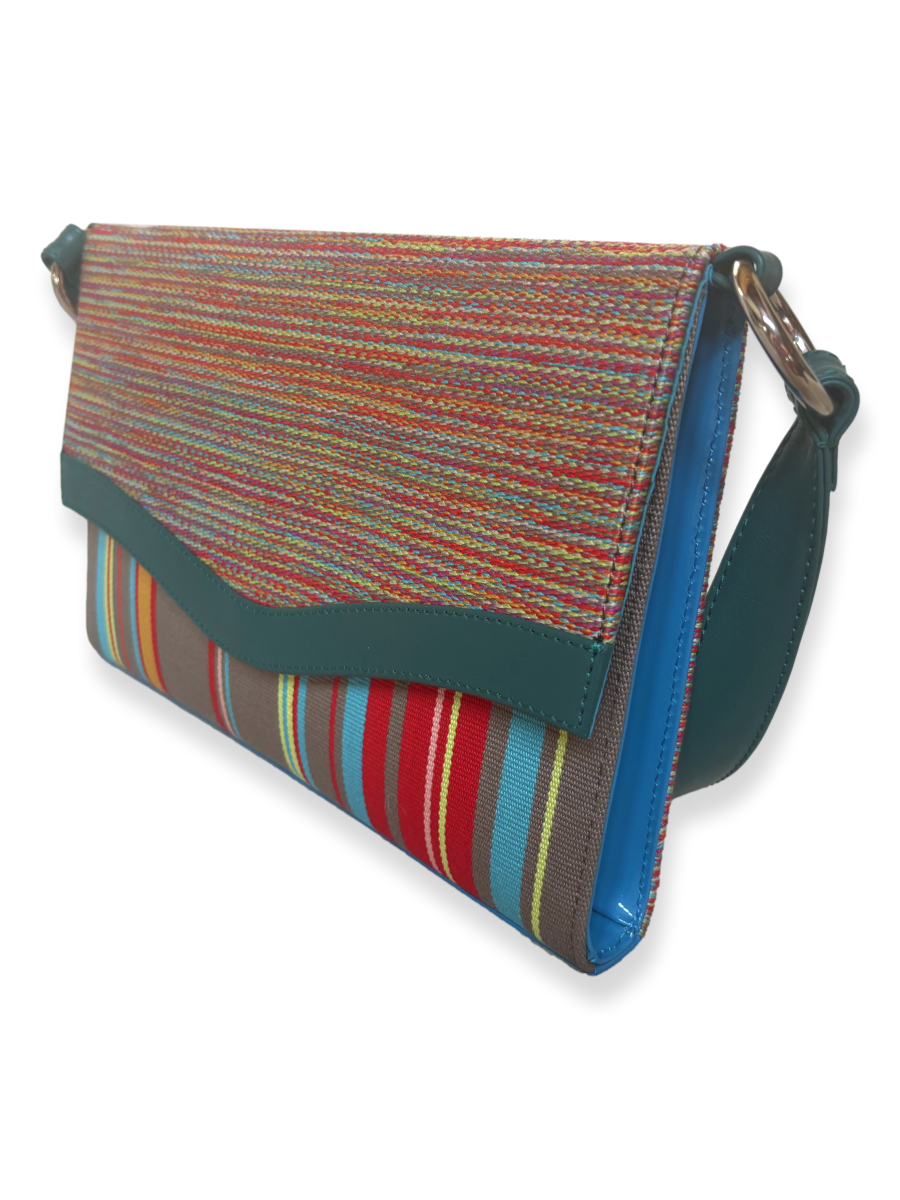Side view of the Onda designer handbag showcasing turquoise patent leather sides, teal leather trim, and handwoven mercerized Peruvian Pima cotton in vibrant multicolor stripes.