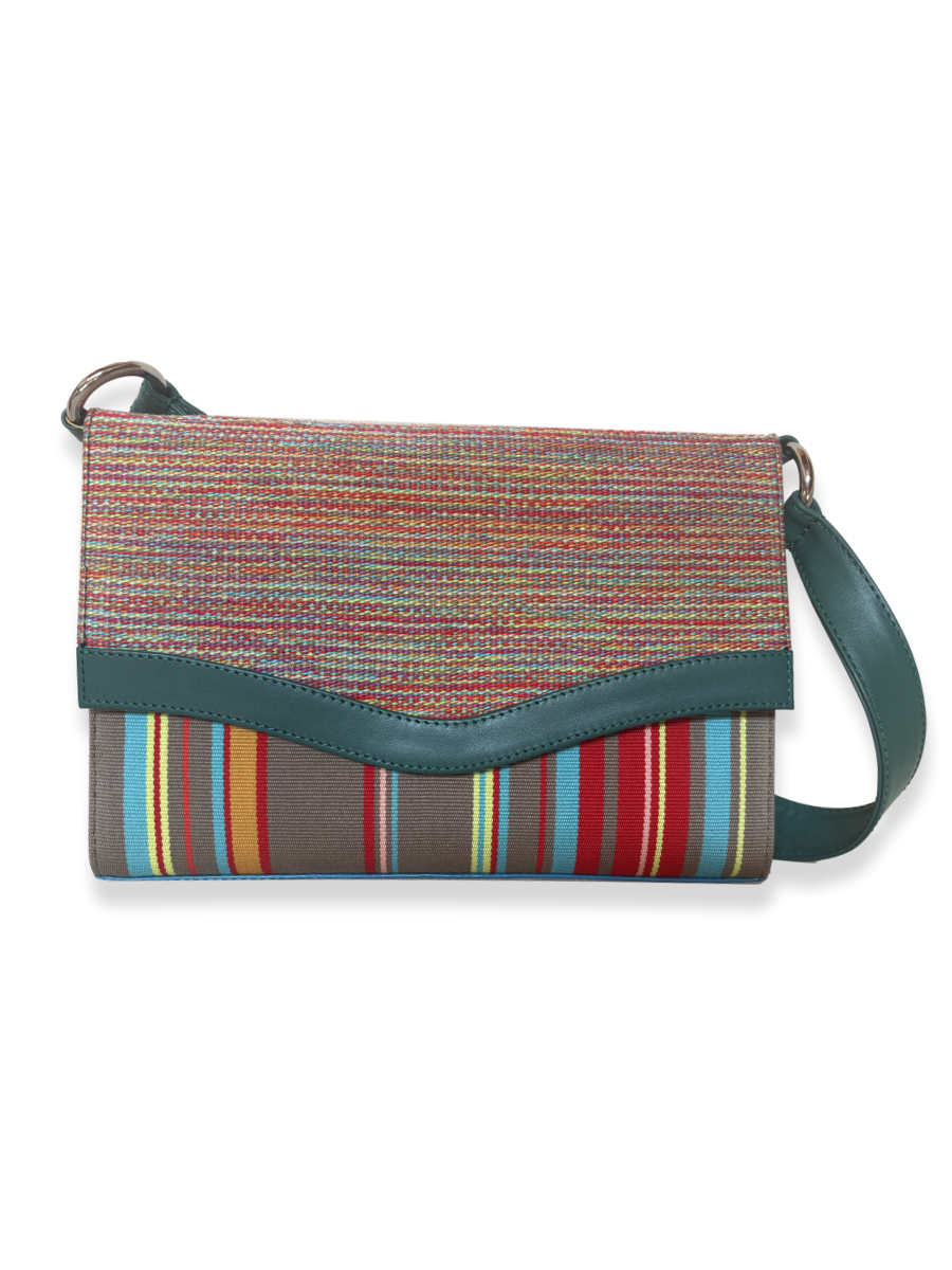 Onda luxury shoulder bag crafted from mercerized Peruvian Pima cotton with signature wave-inspired flap, teal leather trim, turquoise patent leather accents, and colorful woven textile design.