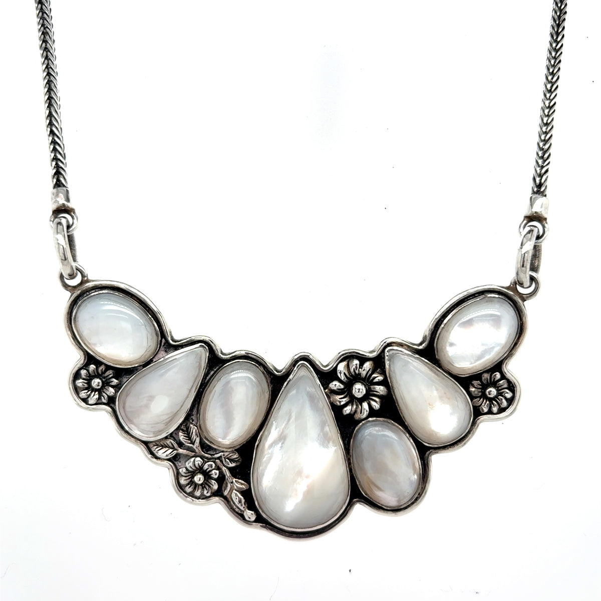 Handcrafted 950 sterling silver necklace with multiple teardrop-shaped mother of pearl stones and floral detailing on a silver chain, front Qinti The Peruvian Shop.