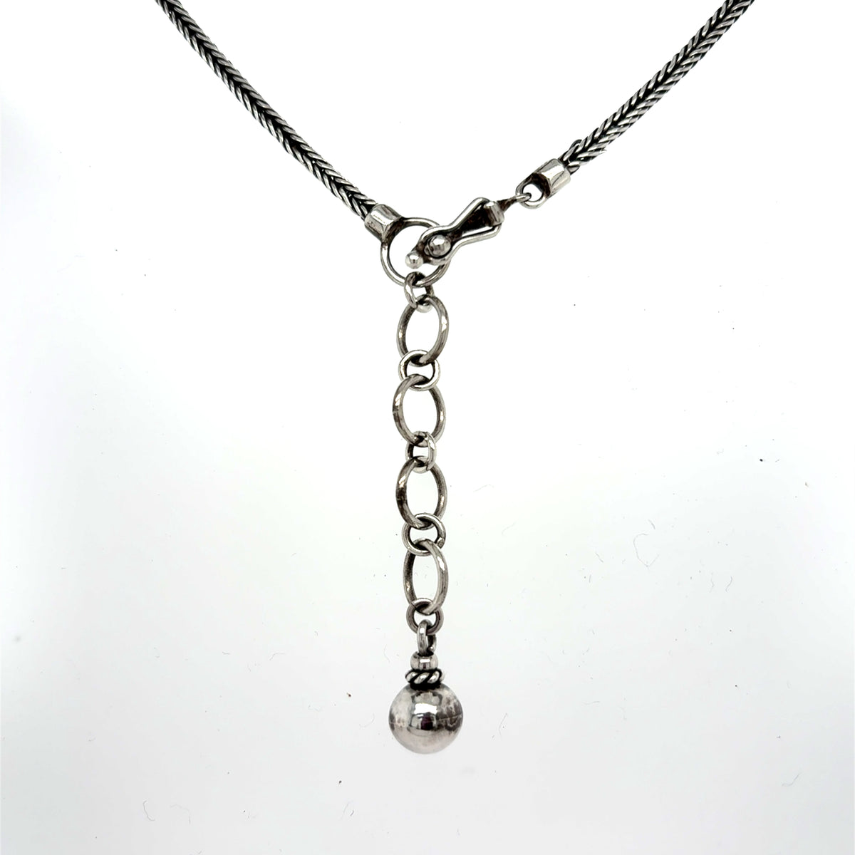 Silver necklace with a chain and spherical pendant from the handcrafted 950 sterling silver necklace with multiple teardrop-shaped mother of pearl stones and floral detailing on a silver chain, front Qinti The Peruvian Shop.