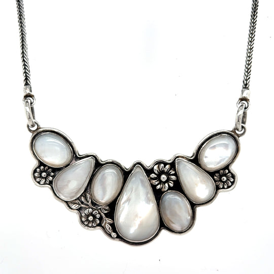Handcrafted 950 sterling silver necklace with multiple teardrop-shaped mother of pearl stones and floral detailing on a silver chain, front Qinti The Peruvian Shop.